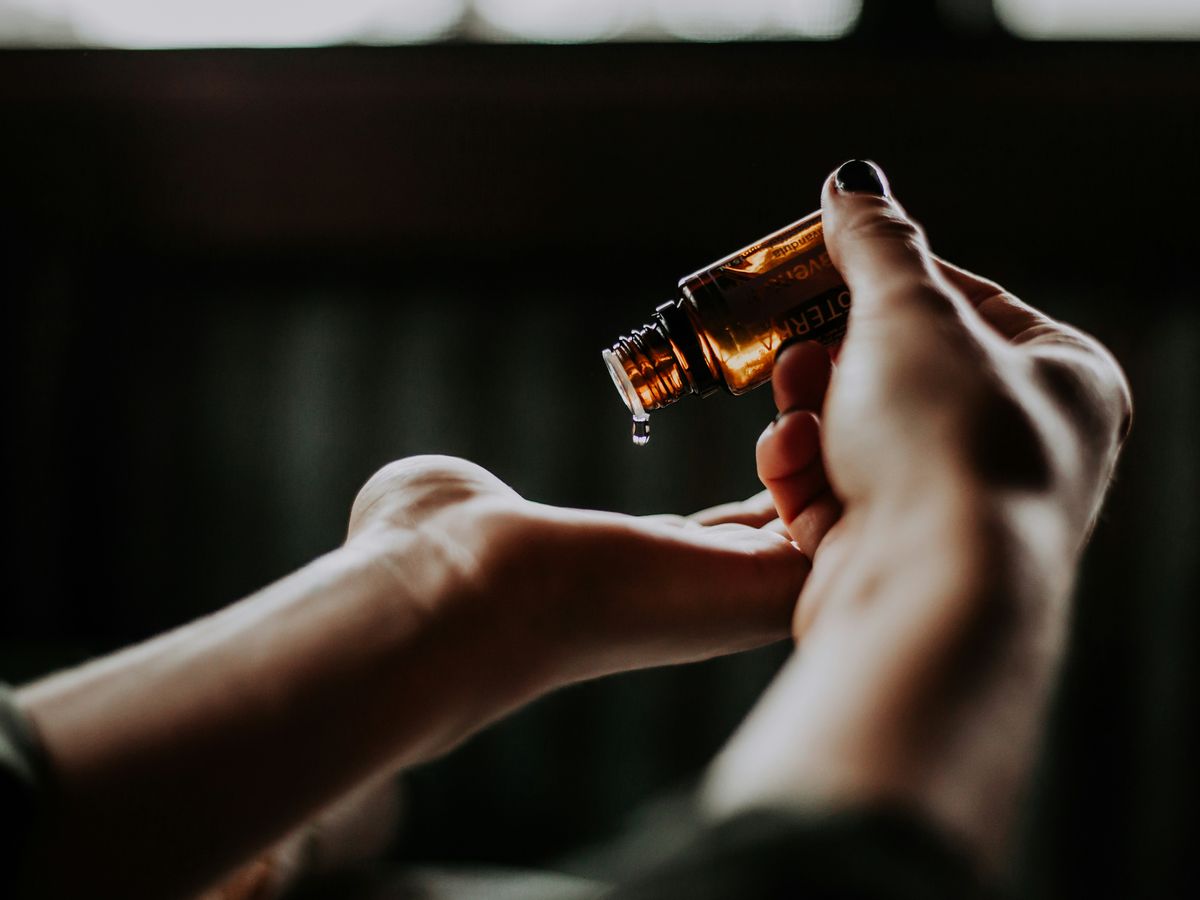 person holding amber glass bottle