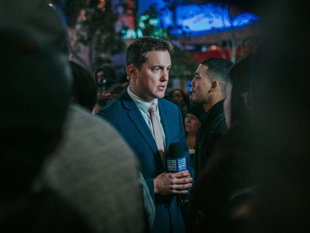 man in black suit standing in front of man in black suit