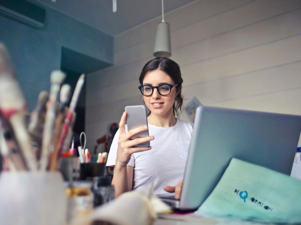 woman in white shirt using smartphone